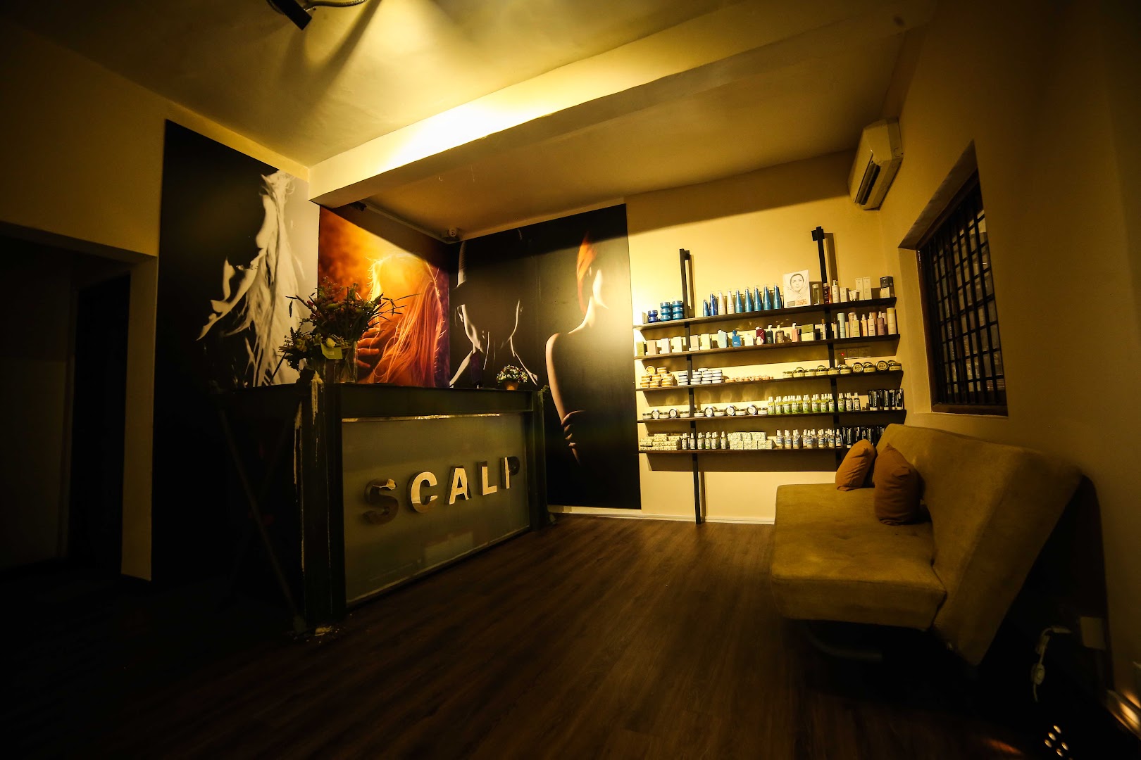 Salon reception with hair murals, product shelving, and dark timber floor