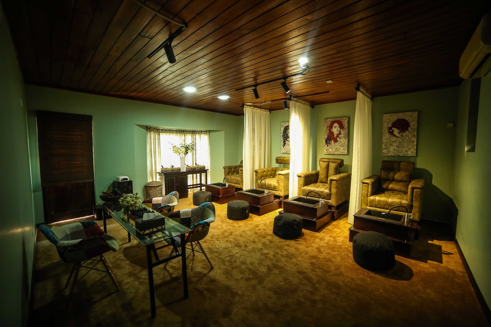 Sage green treatment room with wash stations, cream curtains, and timber ceiling