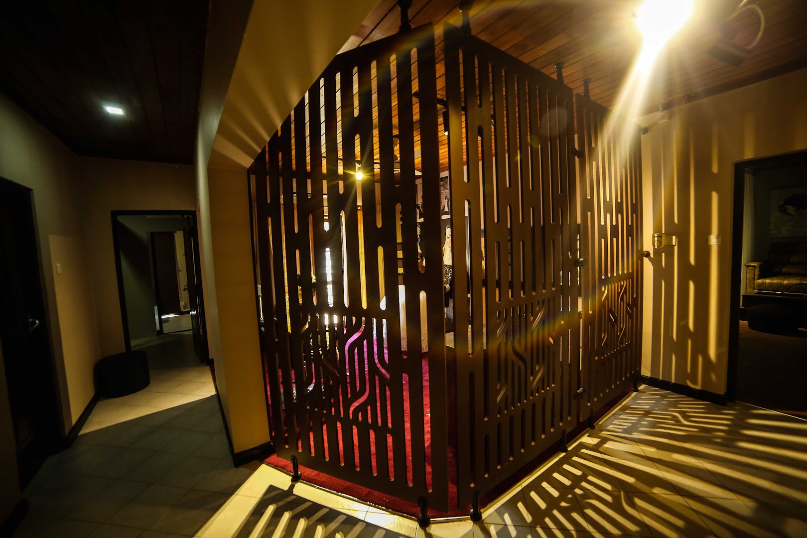 Salon walkway with a black metal screen and warm light